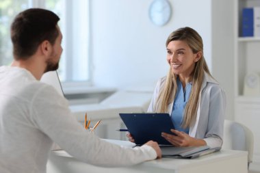 Hastanedeki beyaz masada hastayla çalışan profesyonel bir doktor.