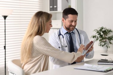 Hastanedeki beyaz masada hastayla çalışan profesyonel bir doktor.