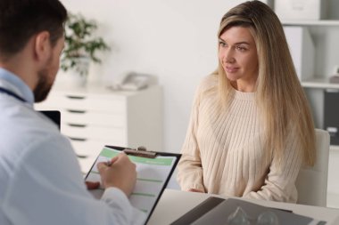 Hastanedeki beyaz masada hastayla çalışan profesyonel bir doktor.