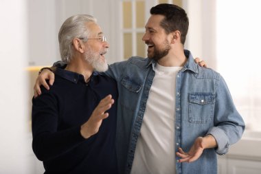 Mutlu oğul ve babası evde konuşuyor.