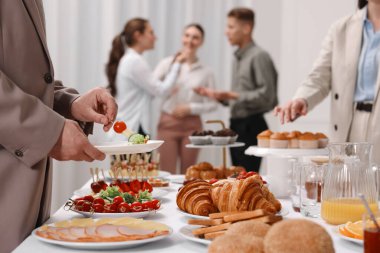 İş arkadaşları restoranda iş yemeği yiyor, yakın plan.