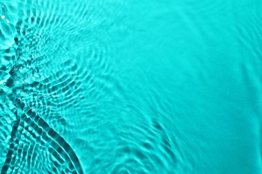 Açık mavi arkaplanda dalgalı temiz su yüzeyi, yakın plan