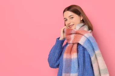 Pembe arka planda sıcak eşarplı güzel kadın, metin için yer