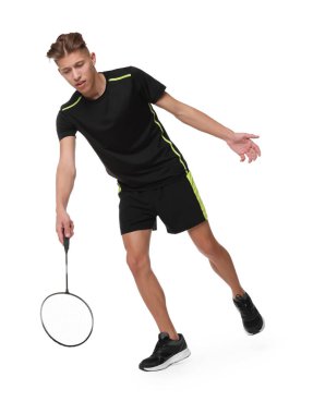 Beyaz arka planda raketle badminton oynayan genç adam.