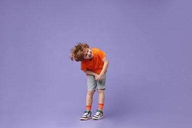 Küçük mutlu çocuk menekşe arka planda dans ediyor. Metin için boşluk