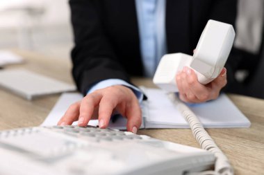 Ofisteki masada sekreterin telefon numarası, yakın plan.