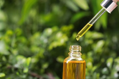 Pipetten dışarıya, şişeye yağ damlatıyorlar, yakın plan.