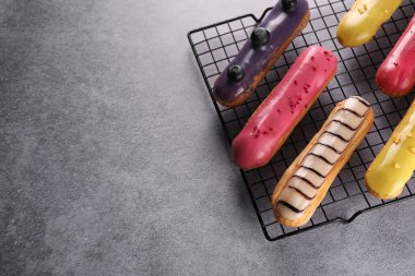 Gri masanın üstünde, üzerinde farklı lezzetli jöleli eklerlerle serinletici raflar. Metin için boşluk