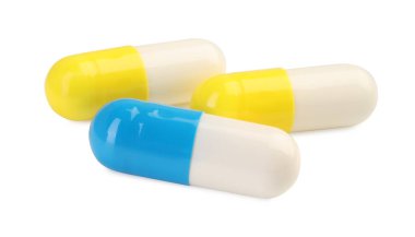 Beyaza izole edilmiş üç antibiyotik hapı. Tıbbi tedavi