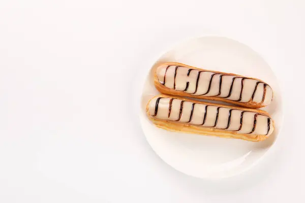 stock image Delicious eclairs covered with glaze on white background, top view