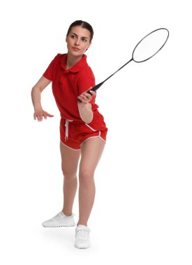 Beyaz arka planda raketle badminton oynayan genç bir kadın.