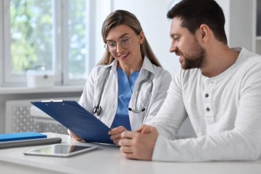 Hastanedeki beyaz masada hastayla çalışan profesyonel bir doktor.