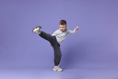 Küçük mutlu çocuk menekşe arka planda dans ediyor. Metin için boşluk