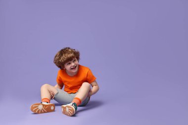 Küçük mutlu çocuk menekşe arka planda dans ediyor. Metin için boşluk