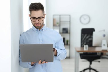 Genç programcı ofiste dizüstü bilgisayar ile çalışma