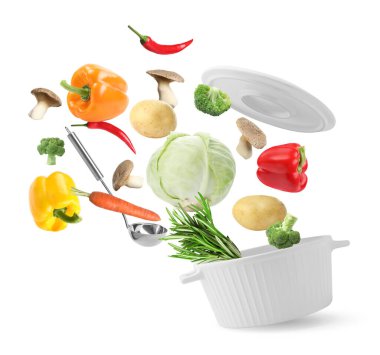 Beyaz arkaplanda tencereye düşen taze malzemeler