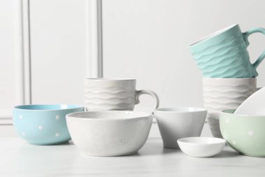 Güzel seramik bulaşık takımı ve bardaklar beyaz masada.