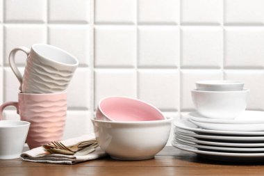 Güzel seramik bulaşık takımı, bardaklar ve çatal bıçak takımı ahşap masada.