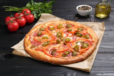 Lezzetli pizza Diablo ve siyah ahşap masa malzemeleri.