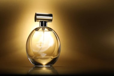 Lüks kadın parfümü. Altın arka planda güneş ışığı şişesi, metin için boşluk