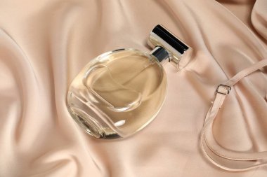 Luxury perfume in bottle on beige silk fabric