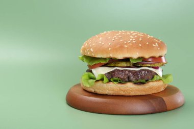 Yeşil arka planda lezzetli köfteli burger. Metin için boşluk