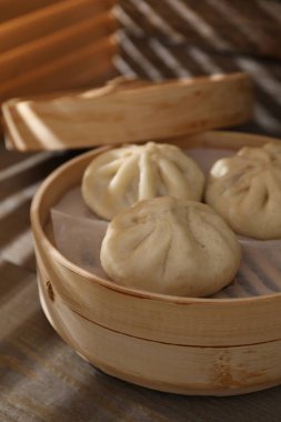 Lezzetli bao çörekleri (baozi) ahşap masada, yakın plan.