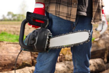 Man with modern saw on sunny day, closeup