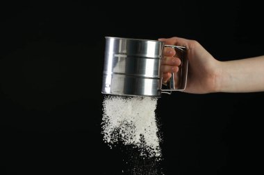 Siyah arka planda un süzen kadın, yakın plan. Metin için boşluk