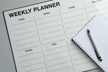 Zaman çizelgesi. Planlayıcı, defter ve kalem gri masa, üst görünüm