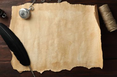 Eski parşömen kağıdı, siyah tüy, mürekkep hokkası, halat ve zincir saat ahşap masa, düz yatıyordu.