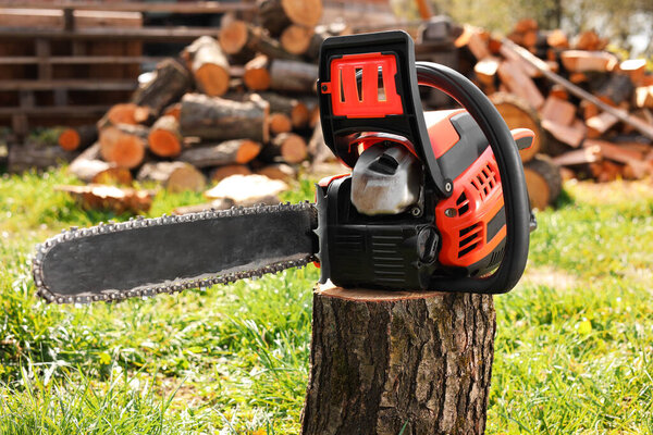 Одна современная пила на деревянном бревне в солнечный день