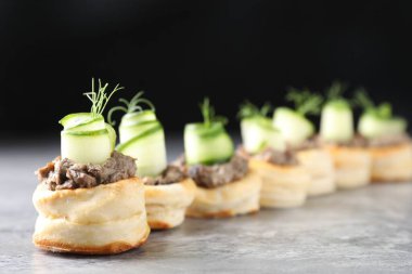 Delicious puff pastry with mushrooms, cucumber and dill on grey table clipart