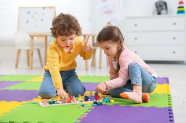 Anaokulundaki bulmaca minderinde matematik oyunu oynayan şirin çocuklar.