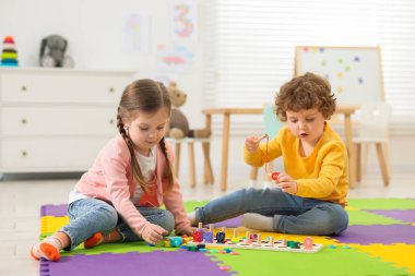 Anaokulundaki bulmaca minderinde matematik oyunu oynayan şirin çocuklar.