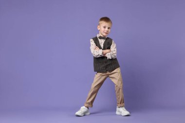 Küçük mutlu çocuk menekşe arka planda dans ediyor. Metin için boşluk