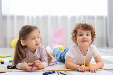 Anaokulunda yere resim çizen şirin çocuklar.