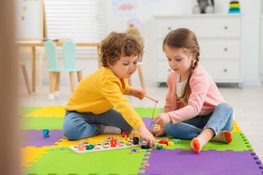 Anaokulundaki bulmaca minderinde matematik oyunu oynayan şirin çocuklar.