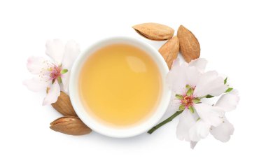 Kavanozda badem yağı, taze fındık ve beyaz manzarada izole edilmiş güzel çiçekler.