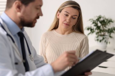Hastanedeki beyaz masada hastayla çalışan profesyonel bir doktor.