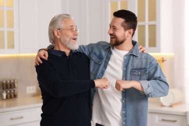 Mutlu oğul ve babası evde yumruk tokuşturuyorlar.