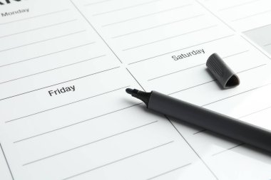 Zaman çizelgesi. Haftalık planlayıcı ve siyah keçeli kalem, yakın plan.