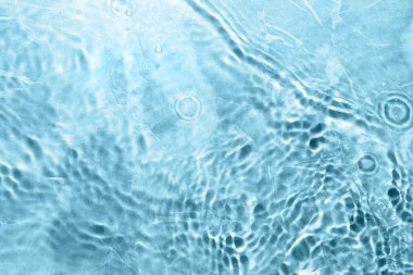 Açık mavi arkaplanda açık suyun dalgalı yüzeyi, üst görünüm