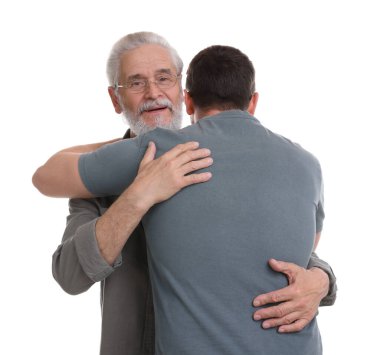 Mutlu baba ve oğlu beyaz arka planda sarılıyorlar.