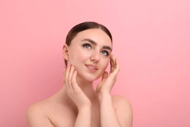 Makyaj ürünü. Siyah göz kalemi ve pembe arka planda güzel kaşları olan bir kadın.