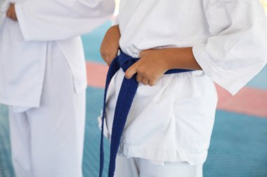 Tatami karate antrenmanı sırasında kimonolu çocuklar, yakın plan.