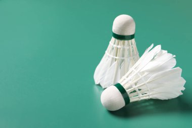 Tüylü badminton mekiği yeşil arka planda, yakın plan. Metin için boşluk