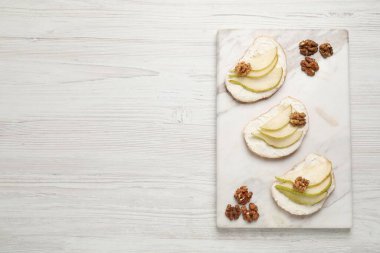 Lezzetli bruschettalar, ricotta peyniri, armut ve ceviz beyaz ahşap masa, üst manzara. Metin için boşluk