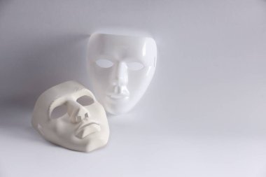 Beyaz arka planda plastik yüz maskeleri, metin için boşluk. Tiyatro performansı