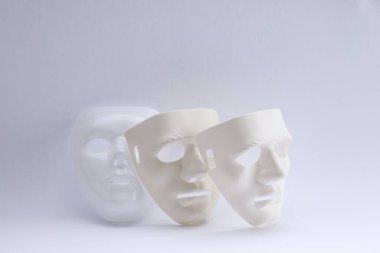 Beyaz arka planda plastik yüz maskeleri. Tiyatro performansı